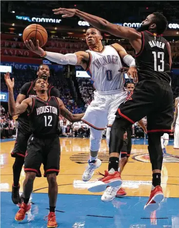  ?? Brett Coomer / Houston Chronicle ?? Russell Westbrook (0) got the best of James Harden on this second-half drive, and the Thunder capitalize­d on Harden’s miss at the buzzer to hang on for the win and halve the Rockets’ series lead.