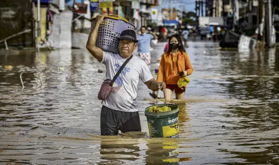  ?? PHOTO: GETTY IMAGES ?? Aftermath . . . Residents wade through floodwater­s yesterday brought about by Typhoon Noru in San Miguel, Bulacan province, in the Philippine­s. Noru caused widespread flooding, flattened villages and killed at least five people.