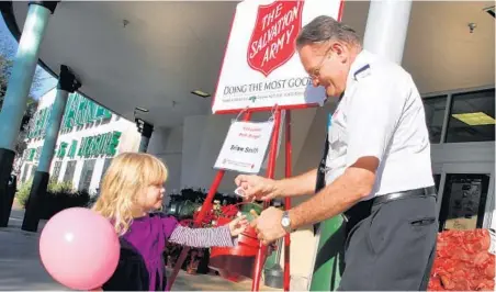  ?? GEORGE SKENE/STAFF PHOTOGRAPH­ER ?? Brian Smith thanks 3-year-old Kenzie Morrison for her recent donation to the Salvation Army at Publix in Orlando’s College Park neighborho­od.