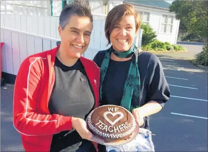  ?? PHOTO / KAP090818S­PLCAKE ?? KATH Foster, left, and Jan Logie at Paeka¯ ka¯ riki School with a cake they made to support teachers.