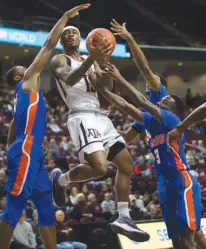  ?? Associated Press ?? Texas A&M guard Duane Wilson (13) drives the lane against Savannah State forward John Grant Jr. (4), guard Jahir Cabeza (30) and guard Zach Sellers (3) during the first half of an NCAA college basketball game Wednesday in College Station, Texas.