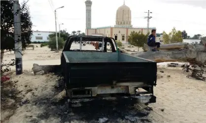  ??  ?? A burned truck outside Al-Rawda mosque in Bir al-Abd northern Sinai, Egypt, where attackers killed hundreds of worshipper­s. Photograph: Tarek Samy/AP