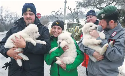  ?? ALESSANDRO DI MEO / ANSA VIA ASSOCIATED PRESS ?? Rescuers hold three puppies that were found alive in the rubble of the avalanche-hit Hotel Rigopiano, near Farindola, Italy, on Monday.