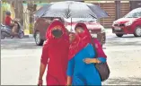  ?? VIPIN KUMAR/HT ?? Pedestrian­s use an umbrella to beat the heat.