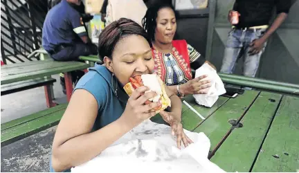  ?? / THULANI MBELE ?? Verona Mahlami tucks into her favourite kota at popular kota spot Ntsintsi’s in Diepkloof, Soweto. The Soweto Theatre will host a kota festival at the weekend.