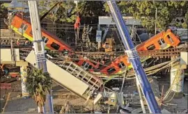  ?? Fernando Llano Associated Press ?? CARS dangle from a section of the Line 12 subway track in Mexico City on May 4, the day after the elevated line buckled, causing the deadly collapse.