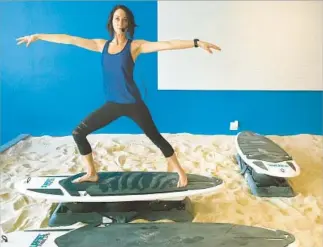  ?? Brian van der Brug Los Angeles Times ?? KATIE SEIGEL at Sandbox Fitness in L.A., known for grueling workouts on a wobbling, elevated surf board in a sandbox. The sand burns about 30% more calories due to added resistance.