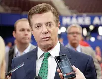  ?? AP Photo/Matt Rourke, File ?? Trump Campaign Chairman Paul Manafort talks to reporters July 17, 2016, on the floor of the Republican National Convention at Quicken Loans Arena in Cleveland as Rick Gates listens at back left.