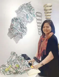  ??  ?? Artisana Island Crafts’ Mary Ann F. Colmenares explains that these wall design and container are woven tarpaulin from the 2016 elections.