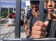  ?? (AP/Marta Lavandier) ?? Kevin Perez of Matanzas, Cuba, calls his grandmothe­r Thursday from a U.S. Customs and Border Protection facility in Marathon, Fla. Perez and other migrants arrived a few days ago after nine days at sea.