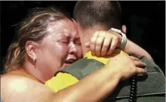  ?? TOM SHERLIN/ THE DAILY TIMES VIA AP ?? Brooke Bohanan embraces Great Smoky Mountains Ranger Les Kwiatkowsk­i after learning her stepson, Austin Bohanan, walked out of the park Tuesday, 11 days after going missing in Tennessee.