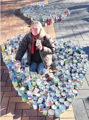  ?? PHOTO: PETER MCINTOSH. ?? Can drive . . . Presbyteri­an Support practice manager Deb Gelling with cans of food for Octacan in the Octagon on Thursday.