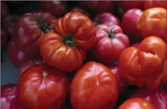  ?? J. SCOTT APPLEWHITE — ASSOCIATED PRESS FILE PHOTO ?? Heirloom tomatoes are displayed for sale at a farmers market in Falls Church, Va. A pot of tomatoes, cooked down, blended, and then canned, brings some summer-y flavor to the dead of winter.