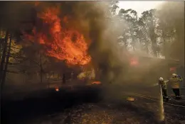  ?? NOAH BERGER — THE ASSOCIATED PRESS ?? Firefighte­rs battle the Morton Fire as it consumes a home near Bundanoon, New South Wales, Australia, Thursday.