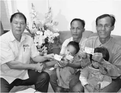  ??  ?? Peter (right) and Mawan (centre) receiving their long-awaited MyKads from Ting.