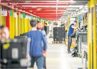  ?? Picture: Kris Miller. ?? Workers at Amazon’s warehouse in Dunfermlin­e.