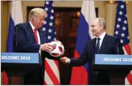  ?? AP PHOTO BY ALEXANDER ZEMLIANICH­ENKO ?? Russian President Vladimir Putin gives a soccer ball to U.S. President Donald Trump, left, during a press conference after their meeting at the Presidenti­al Palace in Helsinki, Finland, Monday, July 16.