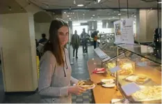  ?? Post-Gazette photos ?? Alyssa Hilliard, a Slippery Rock University student from Butler, orders a black bean burger with fries for lunch on Jan. 24.