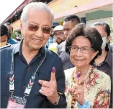  ?? ?? Voted: dr mahathir (left) and his wife Tun dr Siti Hasmah showing off their inked fingers after casting their vote at
SK Titi Gajah in alor Setar, Kedah. — G.c.tan/the Star.