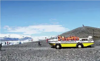  ??  ?? Das Amphibienf­ahrzeug taucht bald für eine Bootsfahrt in den Jökulsárló­n ein