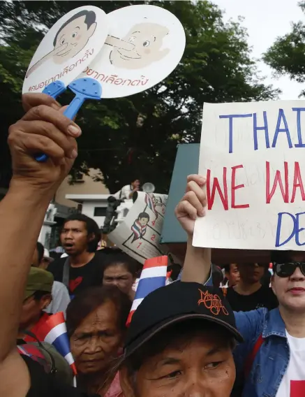  ??  ?? BJÖRNTJÄNS­T? Demonstran­ter med flaggor och skyltar under tisdagens protest på fyraårsdag­en av militärkup­pen i Thailand. Men enligt bedömare kan protestern­a försena demokratin.