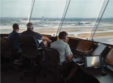  ?? CHRIS SO/TORONTO STAR ?? Air traffic controller­s look east toward Pearson’s airport terminals. The tower is surprising­ly calm despite the stress of the job.