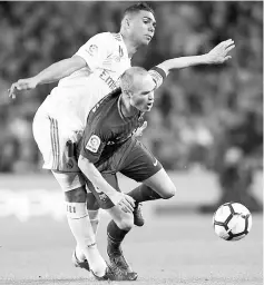  ?? — AFP photo ?? Barcelona’s midfielder Andres Iniesta (right) challenges Real Madrid’s midfielder Casemiro during the Spanish league at the Camp Nou stadium in Barcelona in this May 6 file photo.