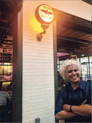  ?? Joe Amarante / Hearst Connecticu­t Media ?? At left, chef and co-owner Arturo Franco-Camacho stands near an atmospheri­c service station sign on the patio at Camacho Garage Wednesday evening. Below, the outdoor patio at Camacho Garage along Central Avenue.