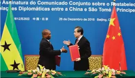  ??  ?? BEIJING: Chinese Foreign Minister Wang Yi (right) shakes hands with his Sao Tome counterpar­t Urbino Botelho after signing an agreement in Beijing yesterday. —AFP