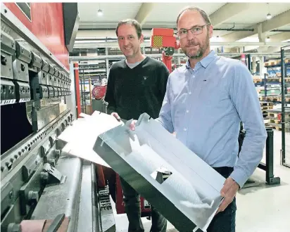  ?? NGZ-FOTO: ANJA TINTER ?? Die geschäftsf­ührenden Gesellscha­fter Jörg (l.) und Ralf Steland zeigen in der Produktion­shalle in Rommerskir­chen zugeschnit­tene und fertig gebogene Blechteile.