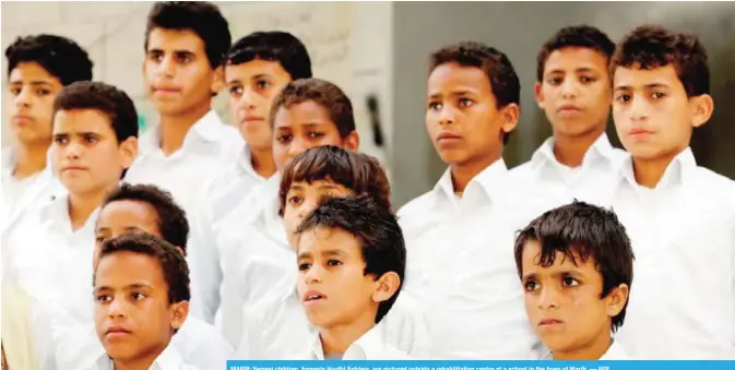  ?? — AFP ?? MARIB: Yemeni children, formerly Houthi fighters, are pictured outside a rehabilita­tion centre at a school in the town of Marib.