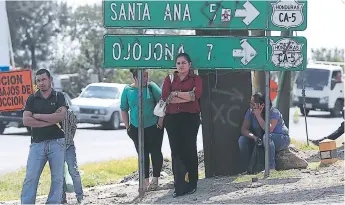  ?? FOTO: ALEX PÉREZ ?? Varios grupos de personas salieron al cruce de Ojojona y Santa Ana para esperar un bus de la zona sur con la finalidad de no perder el día de trabajo en la capital.