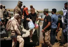  ??  ?? Iraqi forces help displaced people cross the Tigris river by a military boat after the bridge had been closed, south of Mosul