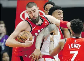  ?? DAVID GOLDMAN / THE ASSOCIATED PRESS ?? Raptors’ Jonas Valanciuna­s grabs a rebound from John Collins of the Hawks during Wednesday night’s NBA game in Atlanta.