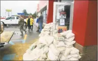  ?? Janet S. Carter / Associated Press ?? Staff at a gas station prepare for severe flooding from Florence with sandbags piled near the entrance Saturday in Kinston, N.C.