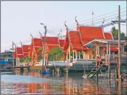  ??  ?? KHLONGS. Así se llaman a los canales de los ríos en Bangkok. En esta imagen, sobre uno de ellos se encuentra este templo, solo accesible en forma acuática. (Izq.) Un tren local se aproxima a la estación Kanchanabu­ri, sobre el río Kwai. (Sup.) El templo...