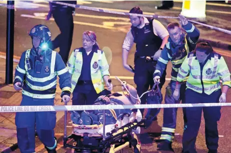  ??  ?? Elementos de seguridad trasladan a uno de los heridos, después de que un vehículo embistió a peatones en la zona del parque Finsbury, en Londres.