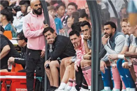  ?? ?? Inter Miami’s Lionel Messi, Sergio Busquets and teammates sit on the bench during their match against a Hong Kong XI at Hong Kong Stadium on Sunday. — Reuters