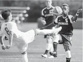  ?? STEVE RUARK/BALTIMORE SUN MEDIA GROUP ?? Calvert Hall’s Chris Carroll, left, and Jared Moses of McDonogh battle for the ball in the first half. Carroll had two assists, including one on the game-winner in overtime.