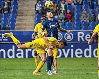  ?? LALIGA ?? Sergio Enrich intenta saltar ante Sergi Cardona, ayer sobre el verde del Carlos Tartiere.