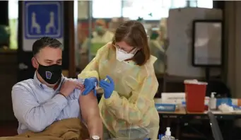  ?? Nancy LanE / hEraLd staFF FILE ?? SHOT AHEAD: Brockton Police Sgt. Scott Besarick is vaccinated by nurse Jeanne Poirier on Jan. 11 at Brockton High School, nine days before President Biden took office.