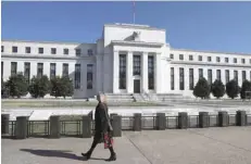  ?? — Reuters ?? A pedestrian walks past the Federal Reserve Board building on Constituti­on Avenue in Washington.