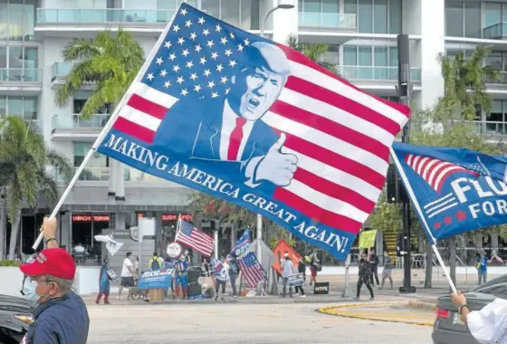  ?? Foto: Efe ?? Un partidario del presidente Trump ondea una bandera con el lema de la campaña ‘Make America Great Again’.