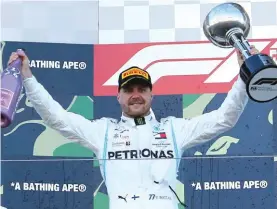  ?? Photo: AP ?? Mercedes driver Valtteri Bottas of Finland raises his trophy on the podium