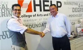  ??  ?? Centre for Foundation Studies Programme, Science/Arts head Michael Phoon congratula­ting Hans Raj on his entry to the University of London Internatio­nal programme after achieving a perfect score in his HELP Foundation studies programme.