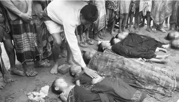  ??  ?? A Bangladesh­i man touches the body of a Rohingya child who drowned after their boat capsized on the Naf river estuary near Teknaf. — AFP photo