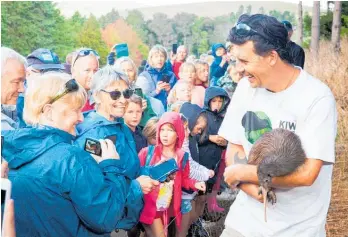  ??  ?? Kiwi handler Cam McInnes with Takoha, one of the kiwi released at Tahere, on the way to Pataua North, on Saturday.