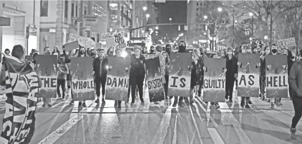  ?? PHOTOS BY KYLE ROBERTSON/COLUMBUS DISPATCH ?? Protesters march up North Front Street in downtown Columbus on Tuesda. Miles Jackson was shot and killed inside Mount Carmel in Westervill­e by police on Monday. Well over 100 demonstrat­ors took to the street.