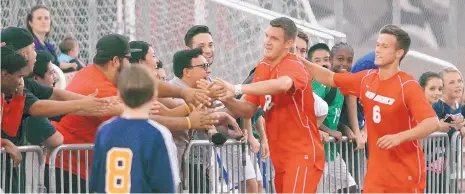  ?? GREG SORBER/JOURNAL FILE ?? In this 2013 file photo, then UNM soccer players Ben McKendry (6) and Kyle Venter slap hands with fans after a Lobo goal during an exhibition match against Grand Canyon. Mayor Tim Keller wrote a letter recently to UNM President Garnett Stokes in support of the program.