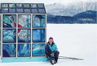  ?? ?? Rocky Harbour, N.L., artist Urve Manuel sits next to her latest creation, a full-size stained-glass ice-fishing shack, that she recently installed on Rocky Harbour Pond. Her plan is to assemble it in various locations around the community throughout the winter.